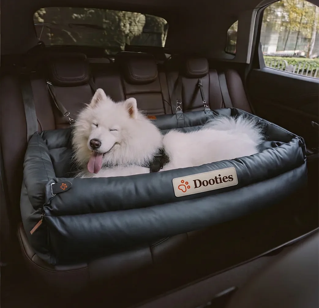 Samoyed sleeping in black dog car seat
